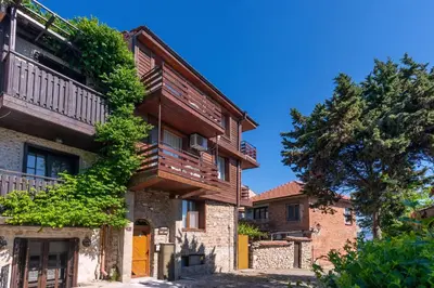 an old house with a balcony and a tree at Royal Blue Apartments with Sea View in Old Nessebar in Nesebar