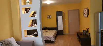 a room with a bedroom with a bed and a living room at Илеа апартамент in Burgas City
