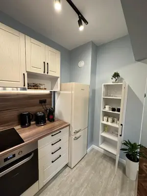 a kitchen with white cabinets and a white refrigerator at Varna Cathedral Boutique Apartment in Varna City