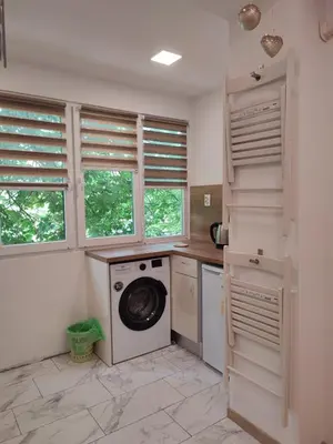 a laundry room with a washing machine and windows at Desafinado in Burgas City