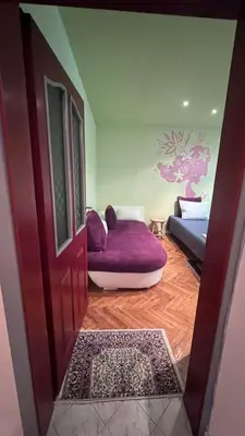a living room with a purple couch and a door at Сладкият кът на Радост in Burgas City