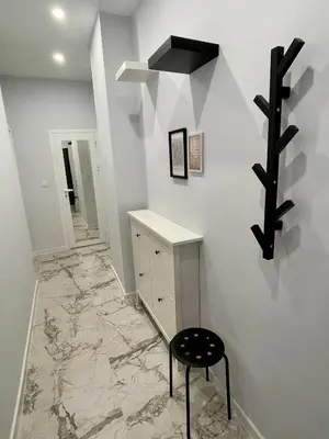 a hallway with a marble floor and a stool in a room at Vanquish Central Apartment in Varna City
