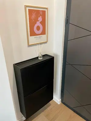 a room with a black dresser and a picture at Vanquish Central Apartment in Varna City