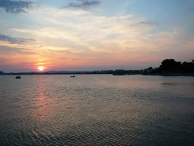 a sunset over a large body of water with boats at Family Hotel Electra in Pomorie