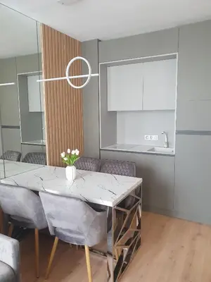 a dining room with a marble table and chairs at Apartament Harmony in Sunny Beach
