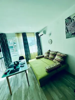 a bedroom with a bed and a table and a couch at Coastal Vibes Studio Burgas by Flat Mаnаger in Burgas City