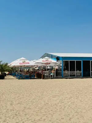 a beach with umbrellas and chairs on the beach at Coastal Vibes Studio Burgas by Flat Mаnаger in Burgas City