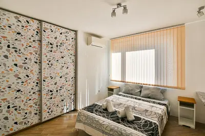 a bedroom with a bed and a large window at Central flat Wi-Fi & streaming in Varna City
