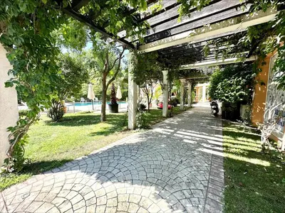 a brick walkway with a pergola in a park at Villa Aria - Menada Apartments in Sunny Beach