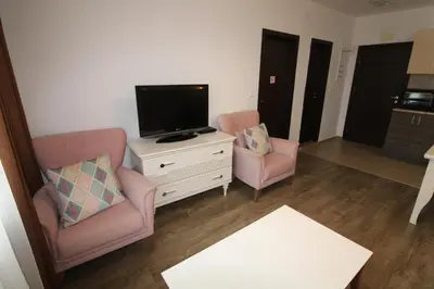 a living room with two chairs and a flat screen tv at Villa Aria - Menada Apartments in Sunny Beach