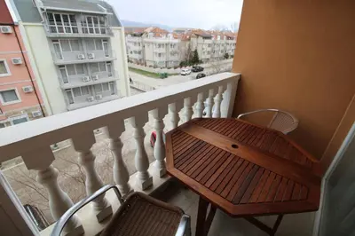 a balcony with a wooden table and a view of a city at Villa Aria - Menada Apartments in Sunny Beach
