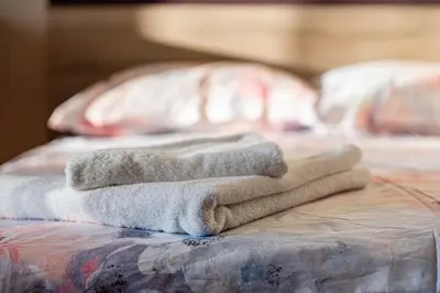 a pile of towels sitting on top of a bed at Primorski 2bdrm Central Apartment in Varna City