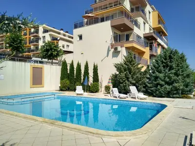 a swimming pool in front of a building at Прекраснные апартаменты с панорамным видом на море in Byala