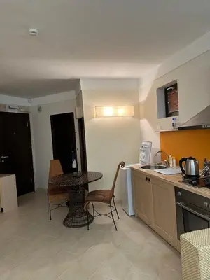 a kitchen with a table and a small table and chairs at Oazis VIP Club in Sunny Beach