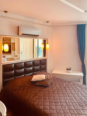 a bedroom with a large bed with a leather headboard at Penthouse Happy Moments 3 in Sunny Beach