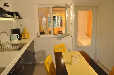 a small kitchen with a table and a sink at Arlequin Apartment in Varna City