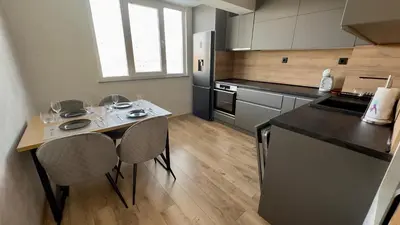 a kitchen with a table with chairs and a refrigerator at Apartment 122 in Burgas City