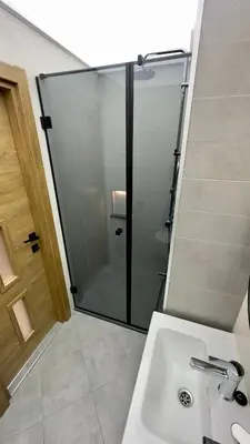a bathroom with a glass shower and a sink at Apartment 122 in Burgas City