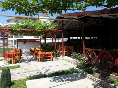a restaurant with tables and chairs in front of a building at Beachfront Havana in Sveti Vlas