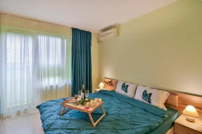 a bedroom with a blue bed and a table at Central Paradise - free parking in Varna City