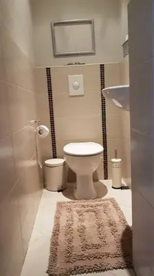 a small bathroom with a toilet and a rug at Central Apartment 5min to beach in Varna City