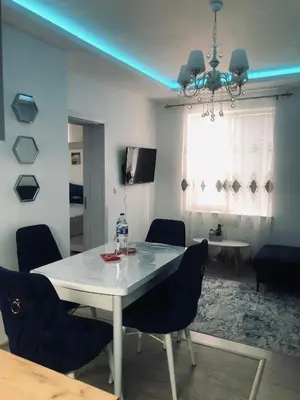 a dining room with a white table and chairs at Bluemoon-Apartment with Parking in Burgas City