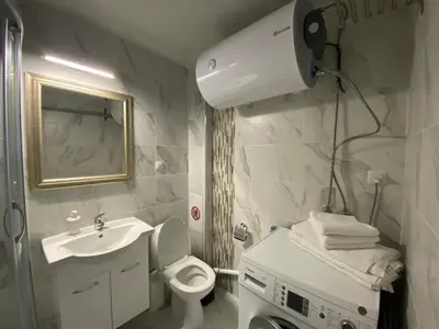a white bathroom with a sink and a toilet at Bluemoon-Apartment with Parking in Burgas City