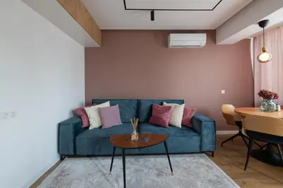 a living room with a blue couch and a table at OPAL Beachfront Apartment in Varna City