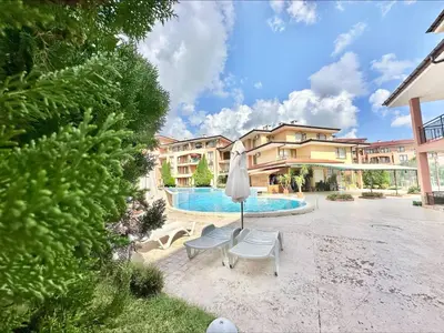 a patio with two chairs and an umbrella and a pool at Panorama Dreams - Menada Apartments in Sveti Vlas
