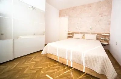 a white bedroom with a bed and a bath tub at Demokratsia bl 117 in Burgas City