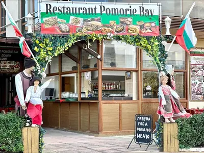 a restaurant promote bay with a statue of a man and woman at Pomorie Bay - Menada Apatments in Pomorie