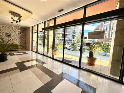 an empty lobby with large windows and a building at Pomorie Bay - Menada Apatments in Pomorie