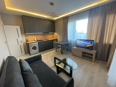 a living room with a couch and a tv and a kitchen at City Center Apartment 2 in Varna City