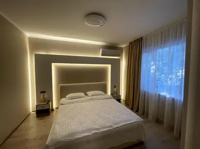 a bedroom with a large bed and a large window at City Center Apartment 1 in Varna City