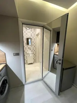 a bathroom with a walk in shower and a washing machine at City Center Apartment 1 in Varna City