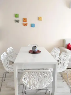 a white dining room table with white chairs at Beachfront Panoramic Flat @ South Bay residence in Varna City
