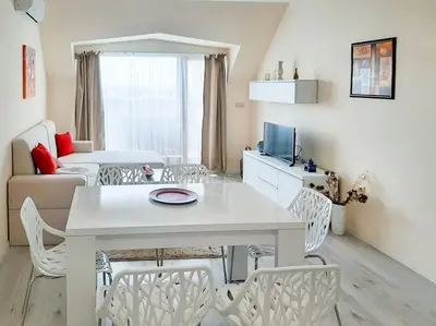 a living room with a white table and chairs at Beachfront Panoramic Flat @ South Bay residence in Varna City