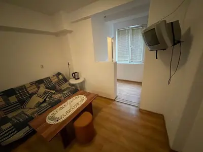 a living room with a couch and a table and a tv at Orange House in Sozopol