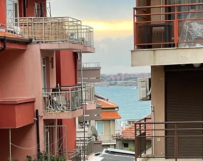 a person sitting on the balcony of a building at Orange House in Sozopol
