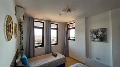 a room with a bed and two windows and a ceiling at Квартира с потрясающим видом in Sveti Vlas