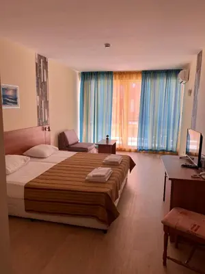 a hotel room with a large bed and a desk at Hotel Star in Sunny Beach