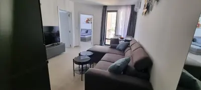 a living room with a couch and a tv at Balcony Bliss: The Black Sea Pearl in Sveti Vlas