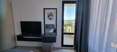 a room with a television and a bedroom with a balcony at Balcony Bliss: The Black Sea Pearl in Sveti Vlas