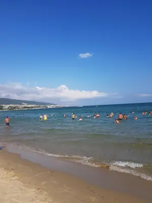 a group of people in the water at the beach at Balcony Bliss: The Black Sea Pearl in Sveti Vlas
