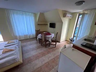 a room with a table and a room with a kitchen at Hotel North in Primorsko