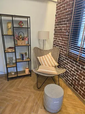 a living room with a chair and a brick wall at The Atelier in Burgas City
