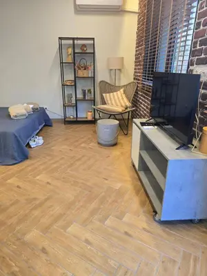 a living room with a tv and a wooden floor at The Atelier in Burgas City