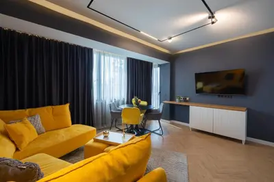 a living room with a yellow couch and a table at TOPAZ Beachfront Apartment in Varna City