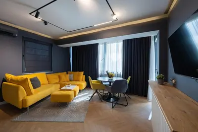 a living room with a yellow couch and a table at TOPAZ Beachfront Apartment in Varna City