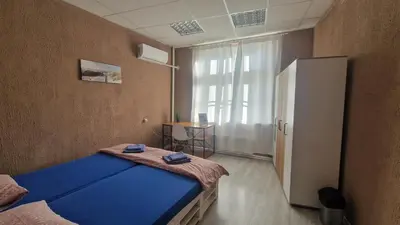 a small room with a blue bed and a window at Lambo's Corner Varna - Guest Rooms in Varna City
